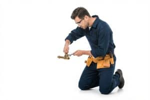Professional plumber working on pipe fitting